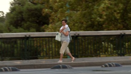 Una mujer cruza el puente de Santiago este miércoles cubriéndose con una chaqueta.