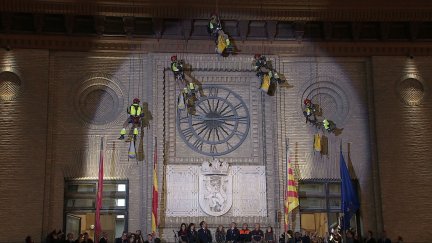 Los bomberos, se edescuelgan por la fachas del Ayuntamiento antes del pregón.