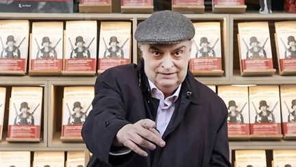 Enrique Vila-Matas posando frente a la puerta de una librería
