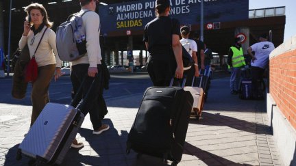Pasajeros con equipaje acuden a la estación de Atocha (Madrid). / EFE