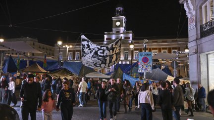 Personas caminan junto a la acampada de Sol este sábado 31 en Madrid. Fernando Villar