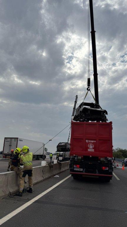 Los bomberos cargando el vehículo híbrido en el camión portacontenedor. / Ayuntamiento de Zaragoza