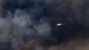 Un helicóptero trabaja en las labores de extinción del incendio forestal en Niebla (Huelva) este sábado, en el que participan veinte medios aéreos, 275 efectivos y 94 vehículos.