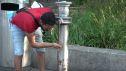 Un hombre refrescándose en una fuente