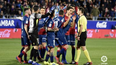 Varios jugaodres del Huesca protestan una decisión a  De Burgos Bengoetxea durante el duelo ante el Sevilla.