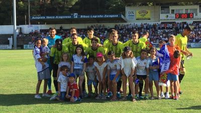 El once del Real Zaragoza ante el Tudelano posa con niños zaragocistas.