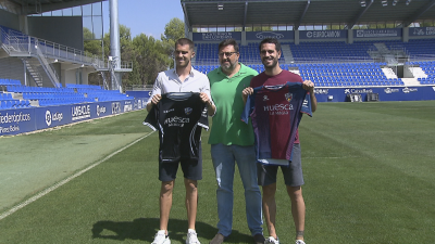 Rubén Yáñez (izquierda) y Pablo Insúa (derecha) posan con las camisetas del Huesca.