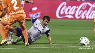 Alberto Zapater ve pasar un balón desde el suelo en un lance del encuentro.