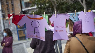 Varias mujeres cuelgan ropa de papel con mensajes simulando una colada (Madrid)