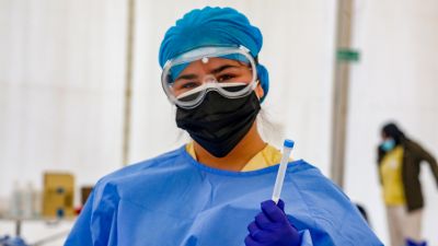 Personal sanitario con EPI y una prueba PCR frente a la COVID-19.