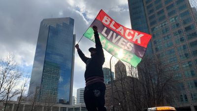 Una persona ondea la bandera del movimiento "Black Lives Matter" tras conocerse el veredicto.