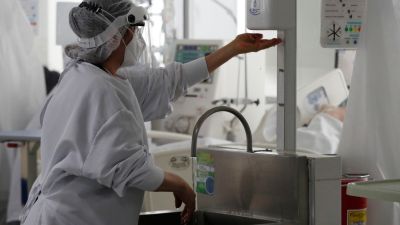 Una sanitaria se desinfecta la manos antes de atender a un paciente.