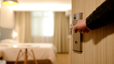 Una persona abre la puerta de su habitación en un hotel.