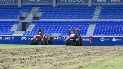 Las máquinas trabajando sobre el césped de El Alcoraz