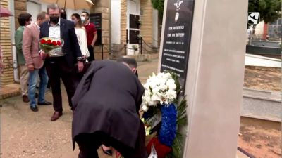 Imagen de un asistente al homenaje depositando un ramo de flores.