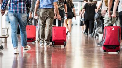 Viajeros con maletas transitan en un aeropuerto.