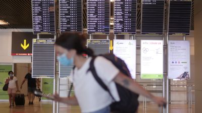 Una mujer camina con su equipaje en la terminal T1 del Aeropuerto de Madrid