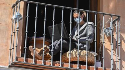 Una mujer trabaja en el balcón de su vivienda (EFE).