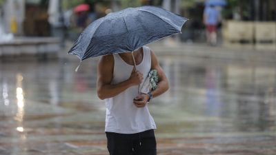 Un hombre se protege de la lluvia con un paraguas (EP).