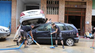 Dos personas limpian la calle después de una inundación (EP).