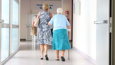 Una mujer visita a un familiar en una residencia.