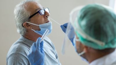 Una sanitaria realiza una PCR a un hombre.
