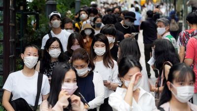 Jóvenes japoneses en las inmediaciones de un centro de vacunación en Tokio (Japón).