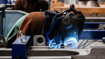 Un empleado trabaja sobre una pieza metálica en una factoría (EP)