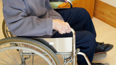 Persona dependiente en silla de ruedas (Canva).