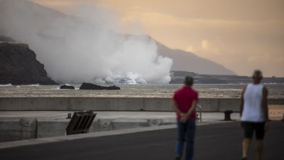 Dos personas ven cómo la lava llega al mar en la costa de Tazacorte (EP):