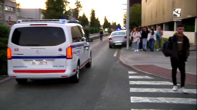 Un grupo de estudiantes desalojados del campus de Lejona pasan junto a una furgoneta de la Ertzaintza.