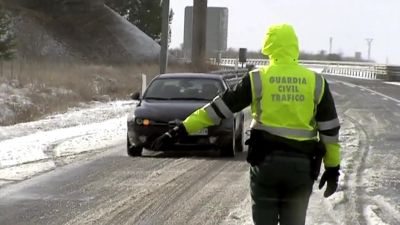 Un agente de la Guardia Civil ordena a un conductor que se detenga ante el estado de la carretera.