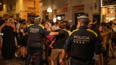 Agentes de la Guardia Urbana de Barcelona se dirigen a la multitud para controlar aglomeraciones en las fiestas del barrio de Gràcia. / Foto: EP