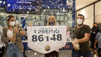 Varias personas, celebrando con champán el primer premio en Atocha. / Foto: EFE