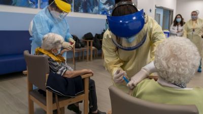 Dos sanitarias vacunan a dos internas en una residencia.