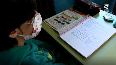 Una niña, sentada en su mesa durante una clase.