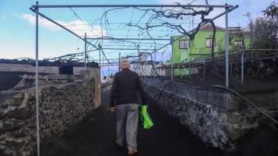 Una persona regresa a su casa tras el cese de la erupción del volcán de La Palma en el barrio de Jedey. Foto: EFE.