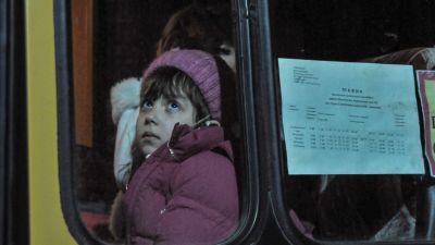 Una niña aguarda dentro de un autobús en el puesto aduanero de Matveev Kurgan. / Foto: EFE