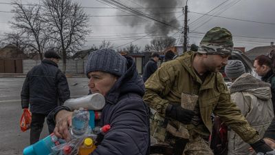 Una mujer recibe agua y productos de higiene distribuidos por el ejército ucraniano a residentes locales en la ciudad de Irpin, situada en la región de Kiev. / EFE/Roman Pilipey