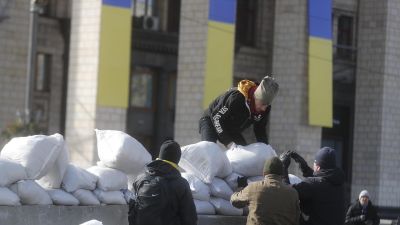 Varias personas realizan una barrera de sacos de arena en Kiev. / Foto: EFE.