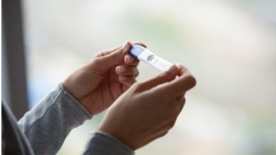 Un mujer sujeta un test de embarazo.