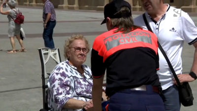Una voluntaria de Protección Civil atiende a una mujer en Zaragoza.