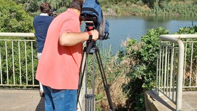 Unos cámaras graban el lugar donde se encontró el cadáver de la mujer, en el río Guadalquivir, en Sevilla. / EFE