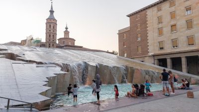 Un grupo de personas se bañan en una fuente en la plaza del Pilar, en Zaragoza. / EFE