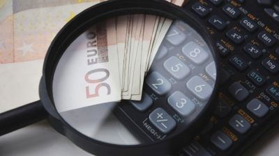 Varios billetes, una calculadora y una lupa. / Europa Press