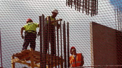 Trabajadores de la construcción realizan un encepado con ferralla en un edifico residencial. / EFE.