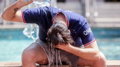 Un joven se echa agua por la cabeza para combatir el calor. / Europa Press