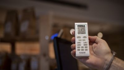 Un empleado pone la temperatura a 27 grados en un establecimiento. / Europa Press.