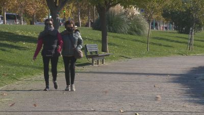 Dos mujeres se protegen del fuerte viento en el Paseo de la Ribera.