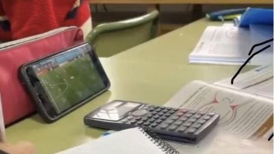 Un alumno sigue un partido del Mundial desde su móvil mientras está en clase.